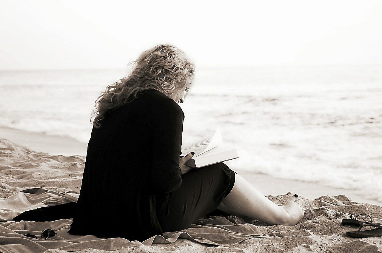 Woman reading a book on a beach